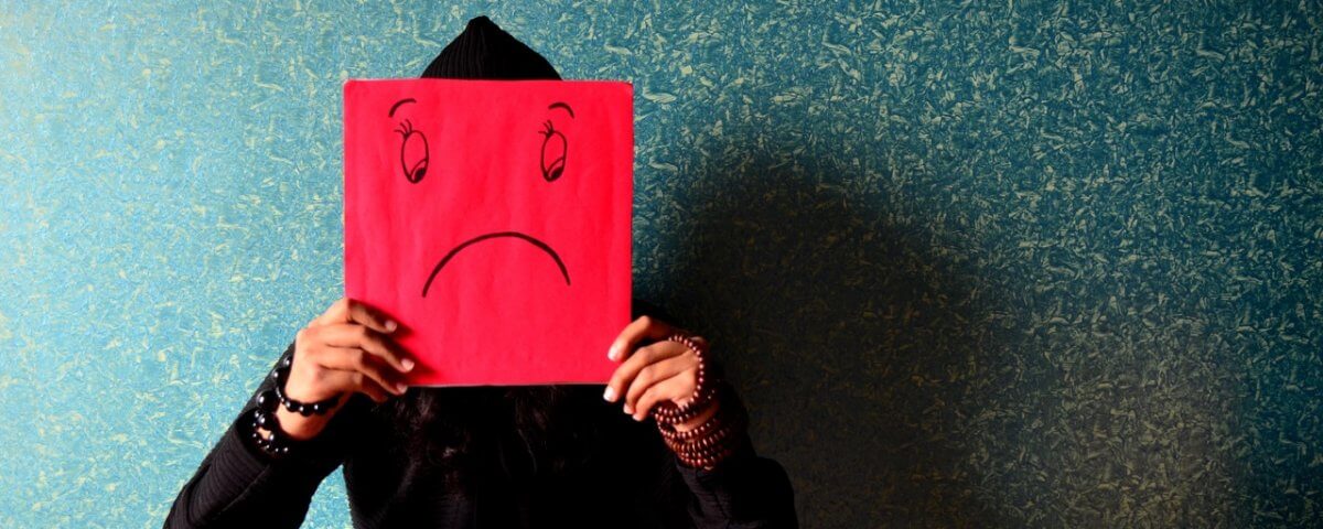 woman holding up sad face