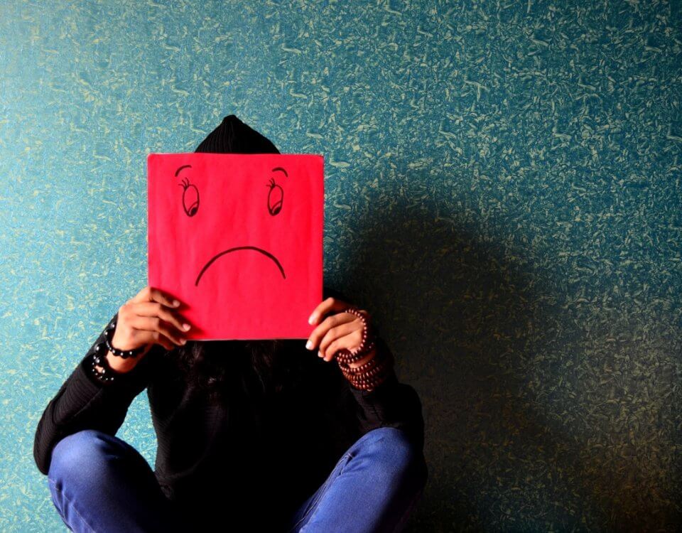 woman holding up sad face